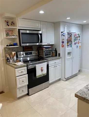 a kitchen with stainless steel appliances a stove a microwave and white cabinets