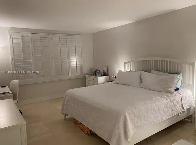 a large bed sitting in a bedroom next to a window