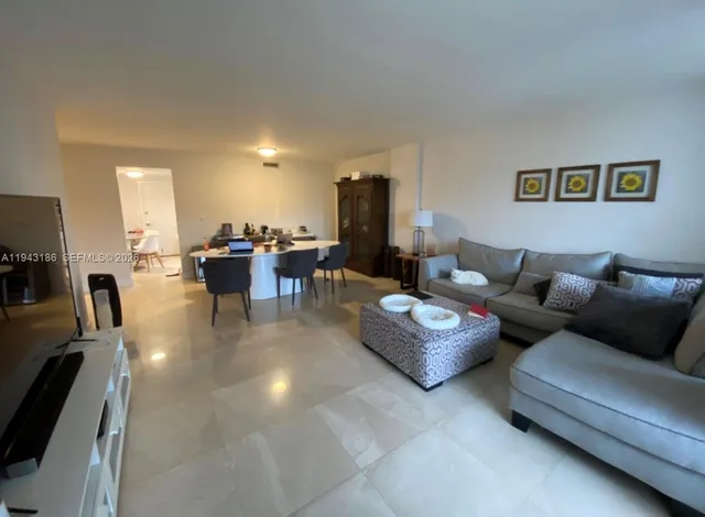 a living room with furniture and a view of kitchen