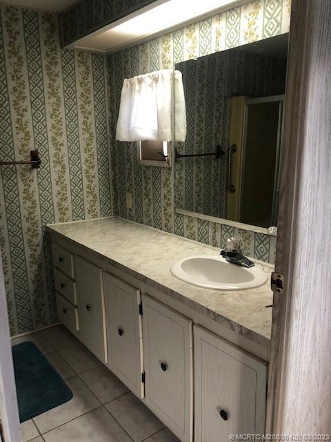21 Los Lagos Road Port St. Lucie, FL 34952 - Photo 17 of 25 a bathroom with a sink and a mirror