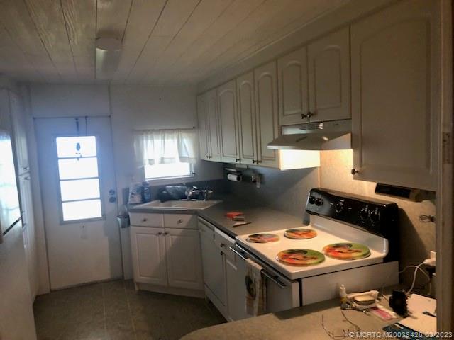 21 Los Lagos Road Port St. Lucie, FL 34952 - Photo 7 of 25 a kitchen with a stove a sink and a refrigerator