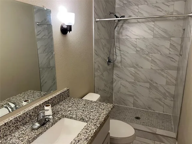 a bathroom with a sink toilet and shower