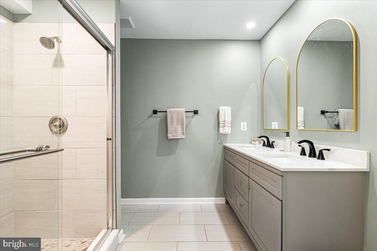 2816 Ballenger Creek Pike Frederick, MD 21703 - Photo 17 of 38 a bathroom with a double vanity sink a mirror and a shower