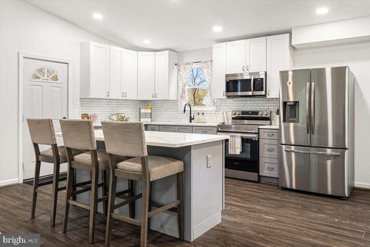 2816 Ballenger Creek Pike Frederick, MD 21703 - Photo 7 of 38 a kitchen with refrigerator cabinets dining table and chairs