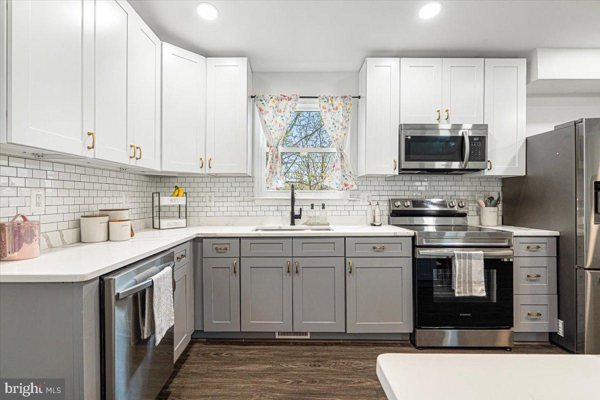2816 Ballenger Creek Pike Frederick, MD 21703 - Photo 9 of 38 a kitchen with stainless steel appliances granite countertop a stove top oven a sink dishwasher and a refrigerator with wooden cabinets