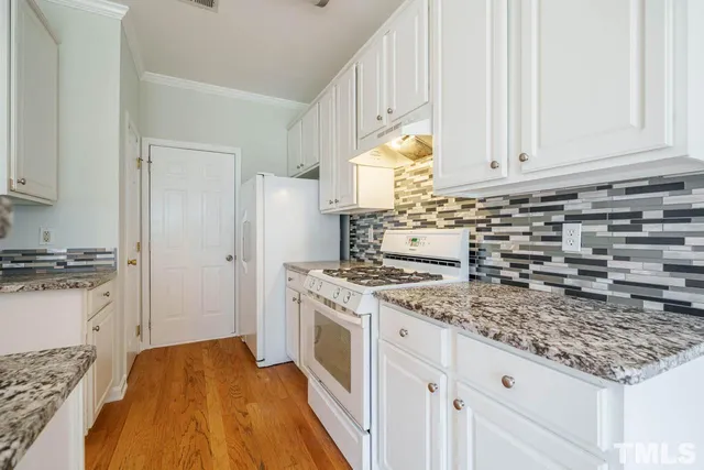 a kitchen with granite countertop a sink stove and cabinets
