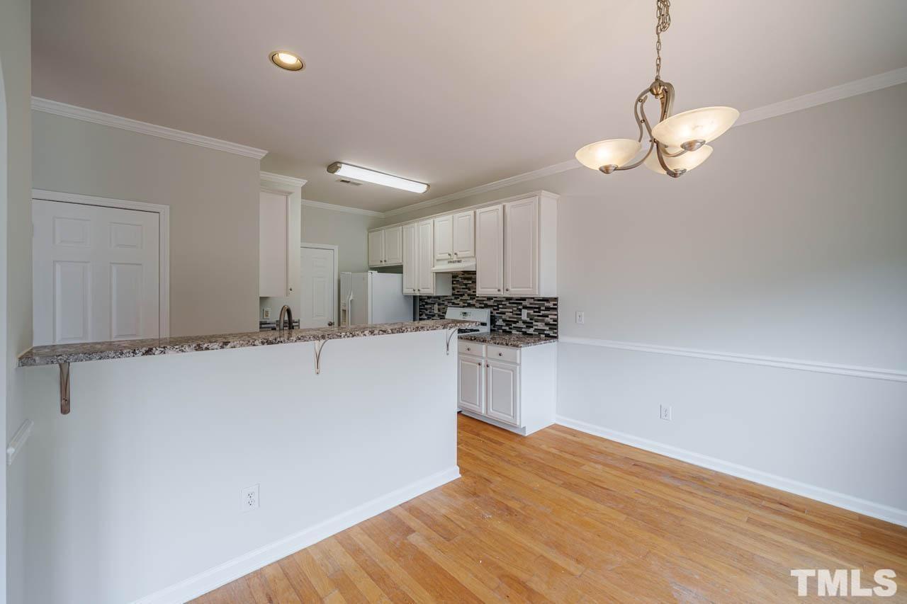 4705 Delta Vision Court, Unit (ID 12461041) Raleigh, NC 27612 - Photo 34 of 35 a view of a kitchen with a sink and dishwasher a refrigerator with wooden floor