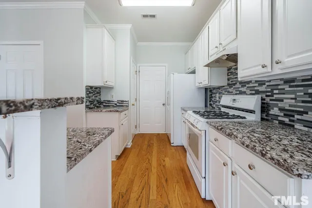a kitchen with stainless steel appliances granite countertop a lot of counter space and wooden floor