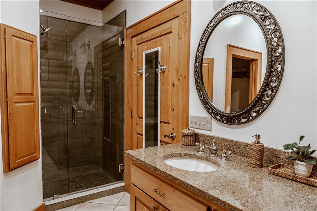 2154 Apple Pie Ridge Road Alto, GA 30510 - Photo 35 of 81 a bathroom with a granite countertop sink a mirror and shower