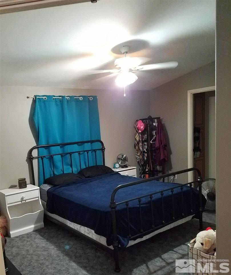 4736 Alcorn Road Fallon, NV 89406 - Photo 5 of 11 a bedroom with a bed a mirror and lamp on desk