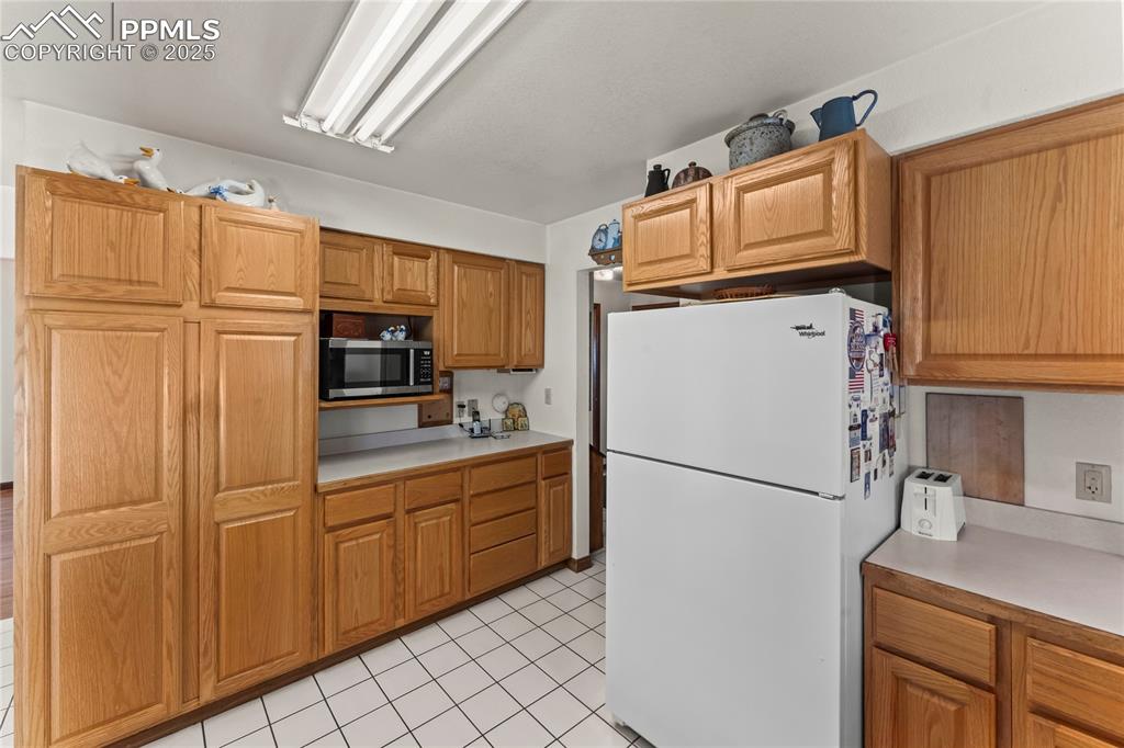 9330 Berridge Road Calhan, CO 80808 - Photo 13 of 50 a kitchen with stainless steel appliances granite countertop a refrigerator a microwave a sink and cabinets