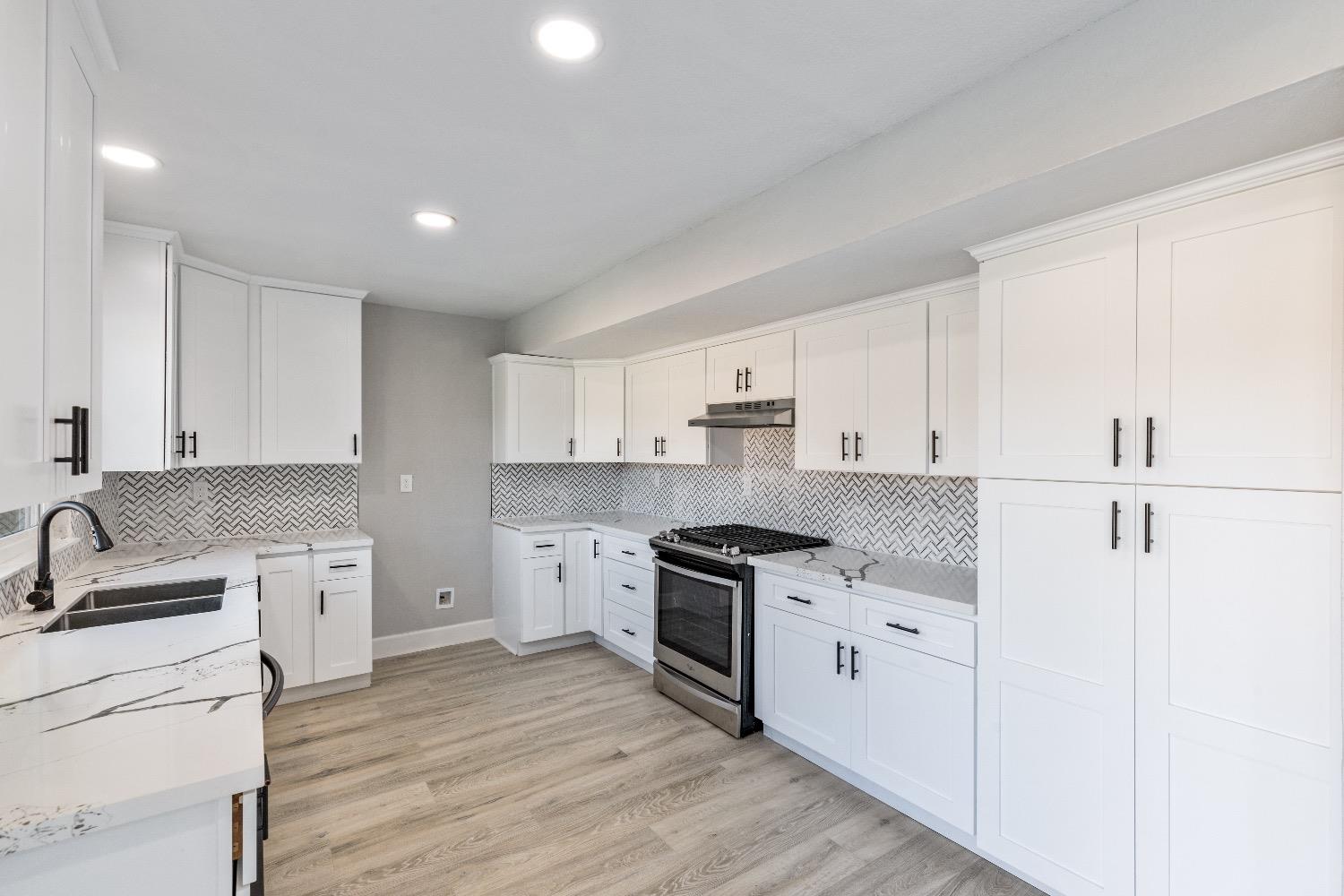 1053 Menlo Avenue Clovis, CA 93612 - Photo 14 of 41 a kitchen with white cabinets sink and stainless steel appliances