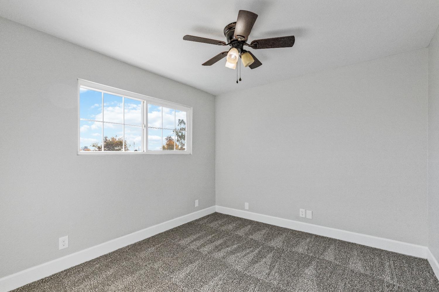 1053 Menlo Avenue Clovis, CA 93612 - Photo 22 of 41 a view of empty room with wooden floor and fan