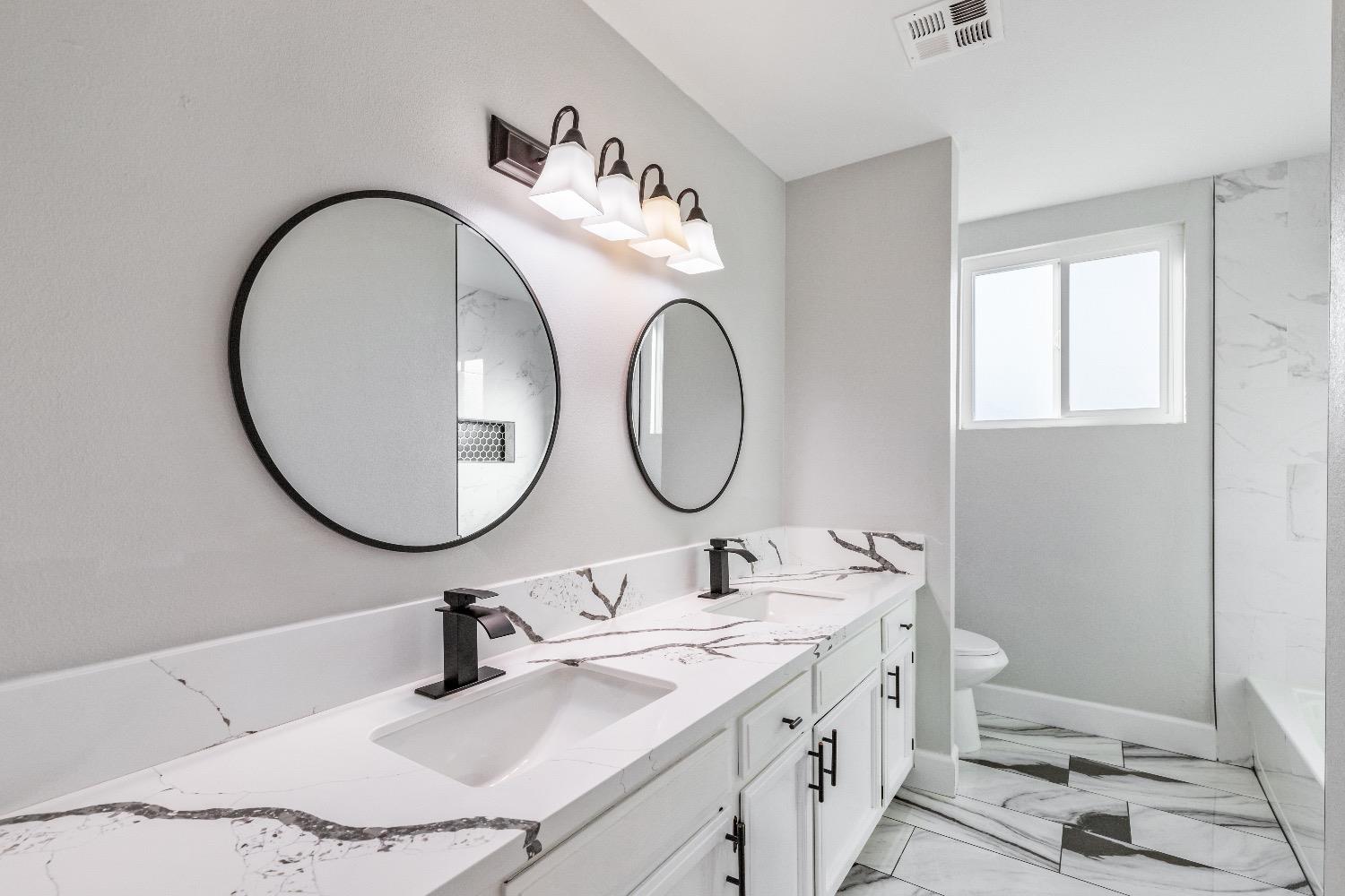 1053 Menlo Avenue Clovis, CA 93612 - Photo 25 of 41 a bathroom with a granite countertop sink and a mirror