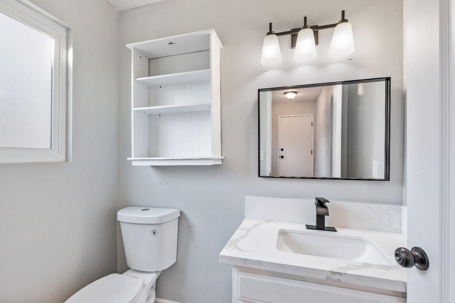 1053 Menlo Avenue Clovis, CA 93612 - Photo 28 of 41 a bathroom with a toilet sink and mirror