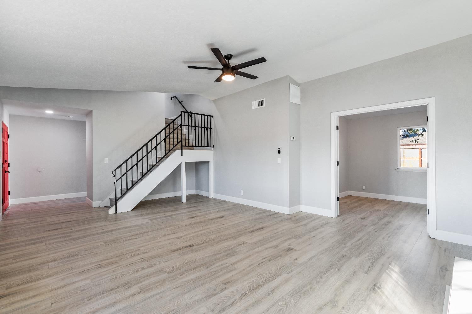1053 Menlo Avenue Clovis, CA 93612 - Photo 9 of 41 an empty room with wooden floor fan and windows