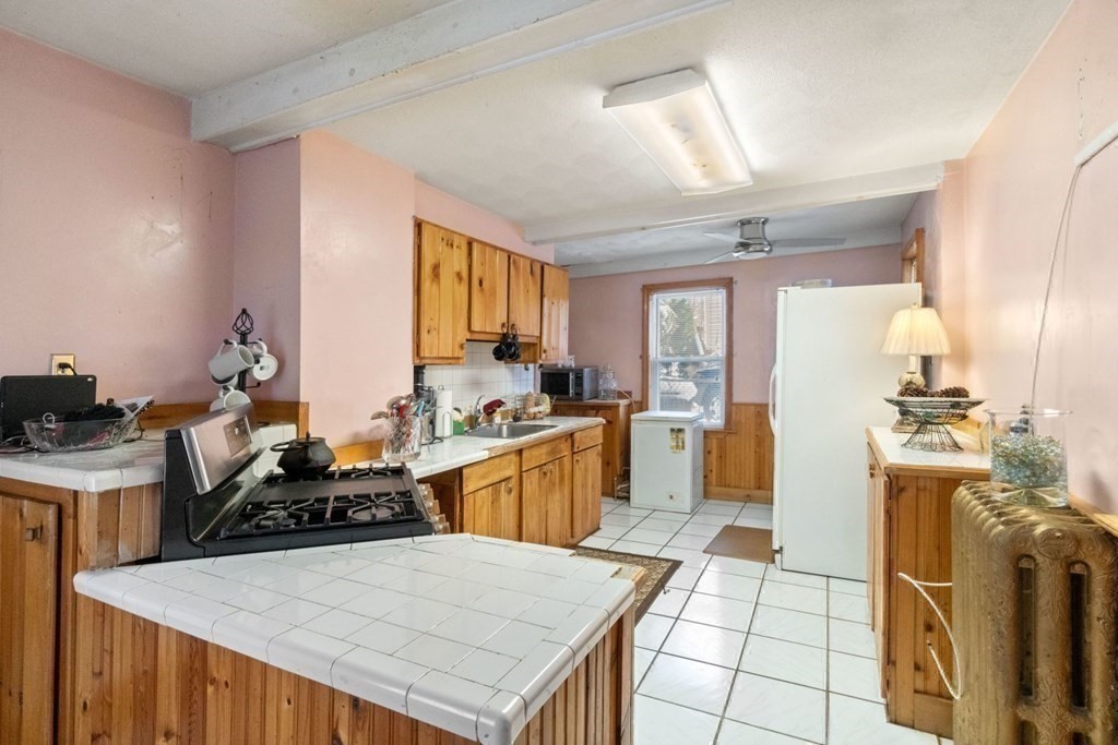 48 Cedar Street Boston, MA 02126 - Photo 16 of 32 a kitchen with a sink a stove a refrigerator and cabinets