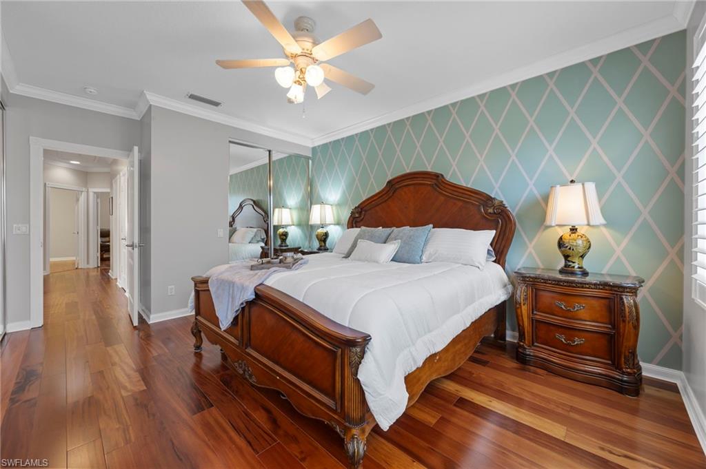5561 Cove Circle Naples, FL 34119 - Photo 24 of 37 a bedroom with a bed and a chandelier