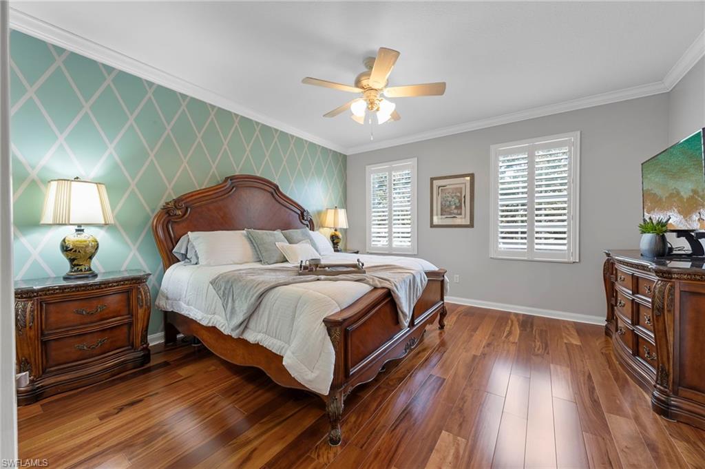 5561 Cove Circle Naples, FL 34119 - Photo 25 of 37 a bedroom with a bed and a flat tv screen on dresser