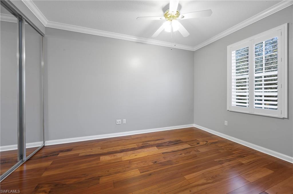5561 Cove Circle Naples, FL 34119 - Photo 30 of 37 a view of an empty room with wooden floor and a window