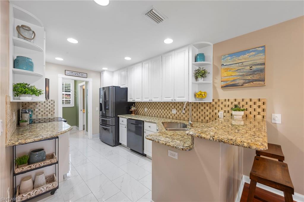 5561 Cove Circle Naples, FL 34119 - Photo 3 of 37 a kitchen with refrigerator and stove