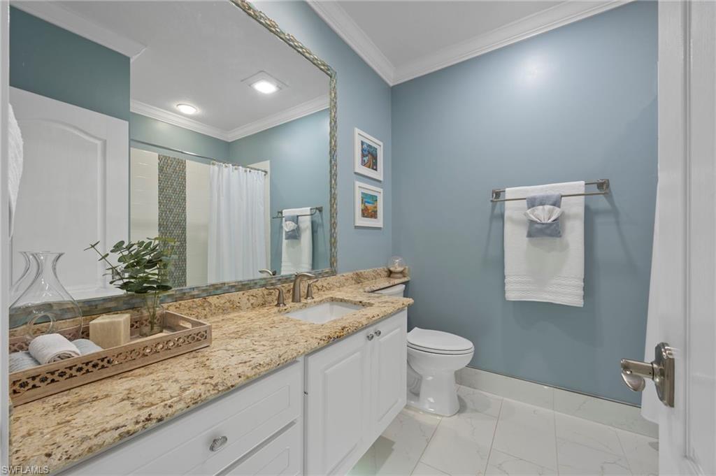 5561 Cove Circle Naples, FL 34119 - Photo 33 of 37 a bathroom with a granite countertop sink and a mirror
