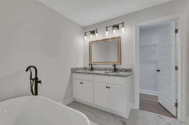 a bathroom with a sink and a mirror with toilet