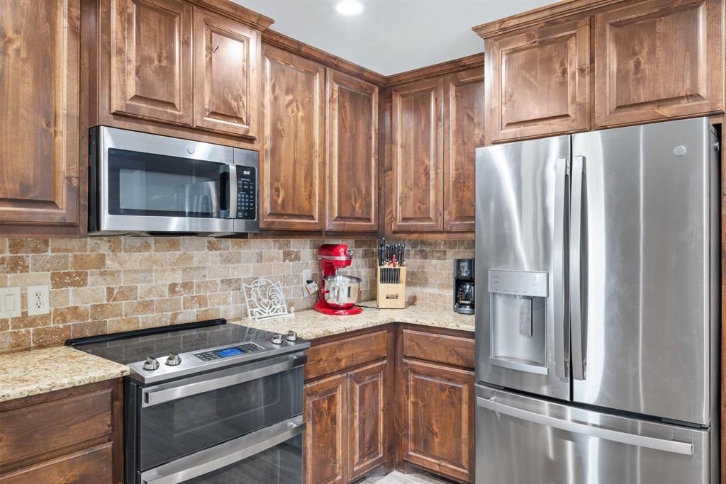 1407 Withers Road Mineral Wells, TX 76067 - Photo 11 of 38 a kitchen with stainless steel appliances granite countertop a refrigerator stove top oven and sink