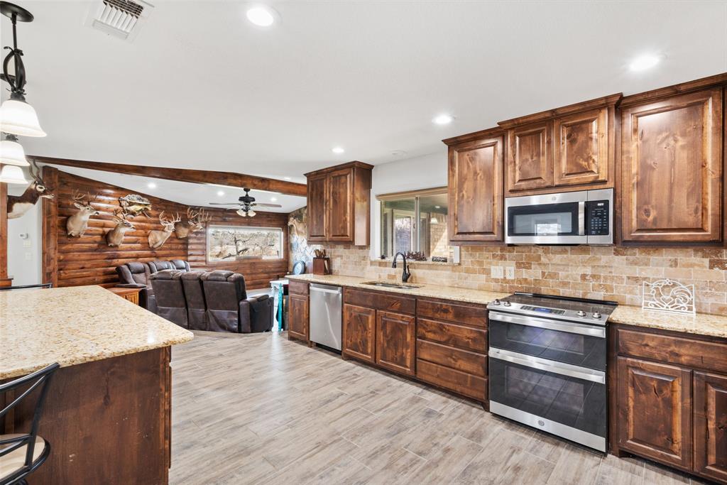 1407 Withers Road Mineral Wells, TX 76067 - Photo 13 of 38 a kitchen with lots of counter top space and wooden floor