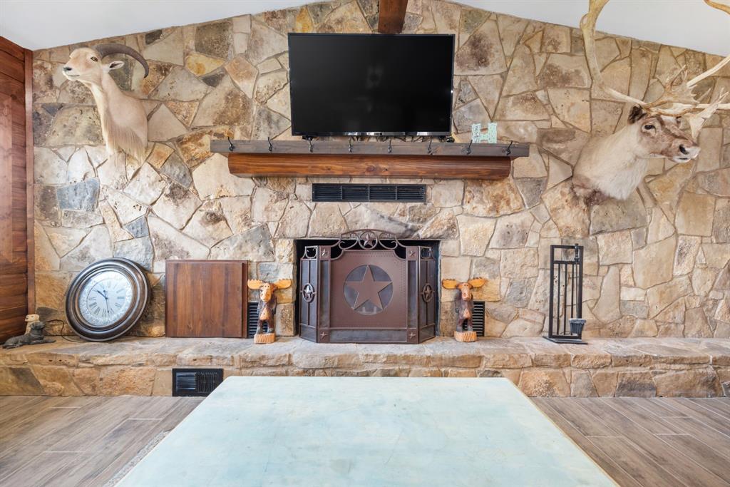 1407 Withers Road Mineral Wells, TX 76067 - Photo 15 of 38 a living room with a fireplace and a flat screen tv