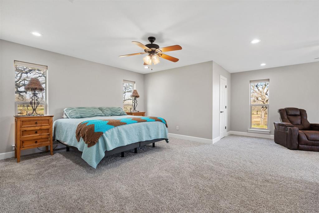 1407 Withers Road Mineral Wells, TX 76067 - Photo 17 of 38 a bedroom with a bed and a chandelier