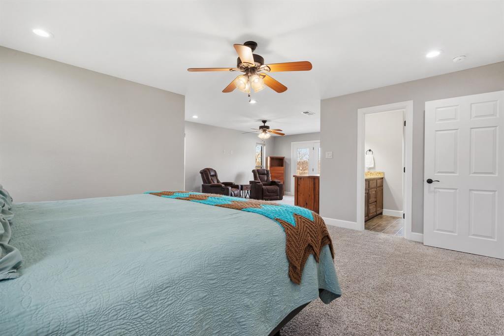 1407 Withers Road Mineral Wells, TX 76067 - Photo 18 of 38 a bed room with a bed and a chandelier