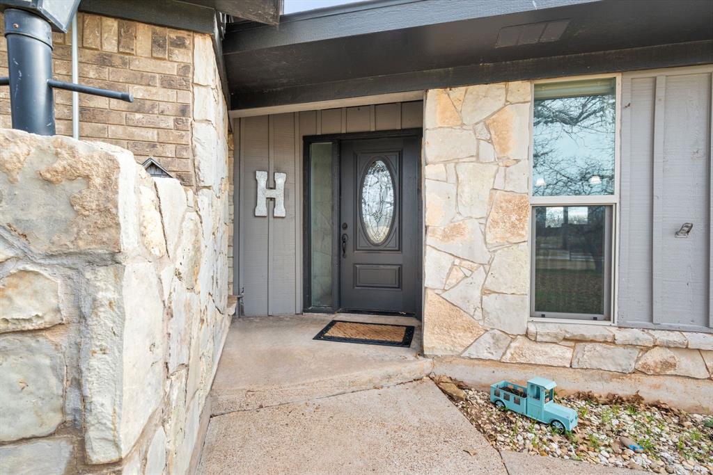1407 Withers Road Mineral Wells, TX 76067 - Photo 4 of 38 a front view of a house with a garden