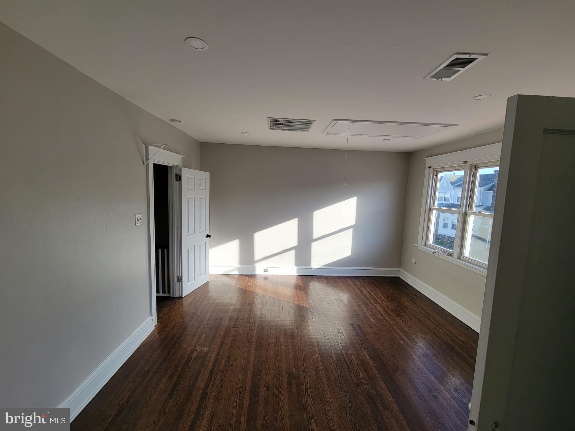 7243 Calvin Road Upper Darby, PA 19082 - Photo 18 of 29 a view of an empty room with wooden floor and a window
