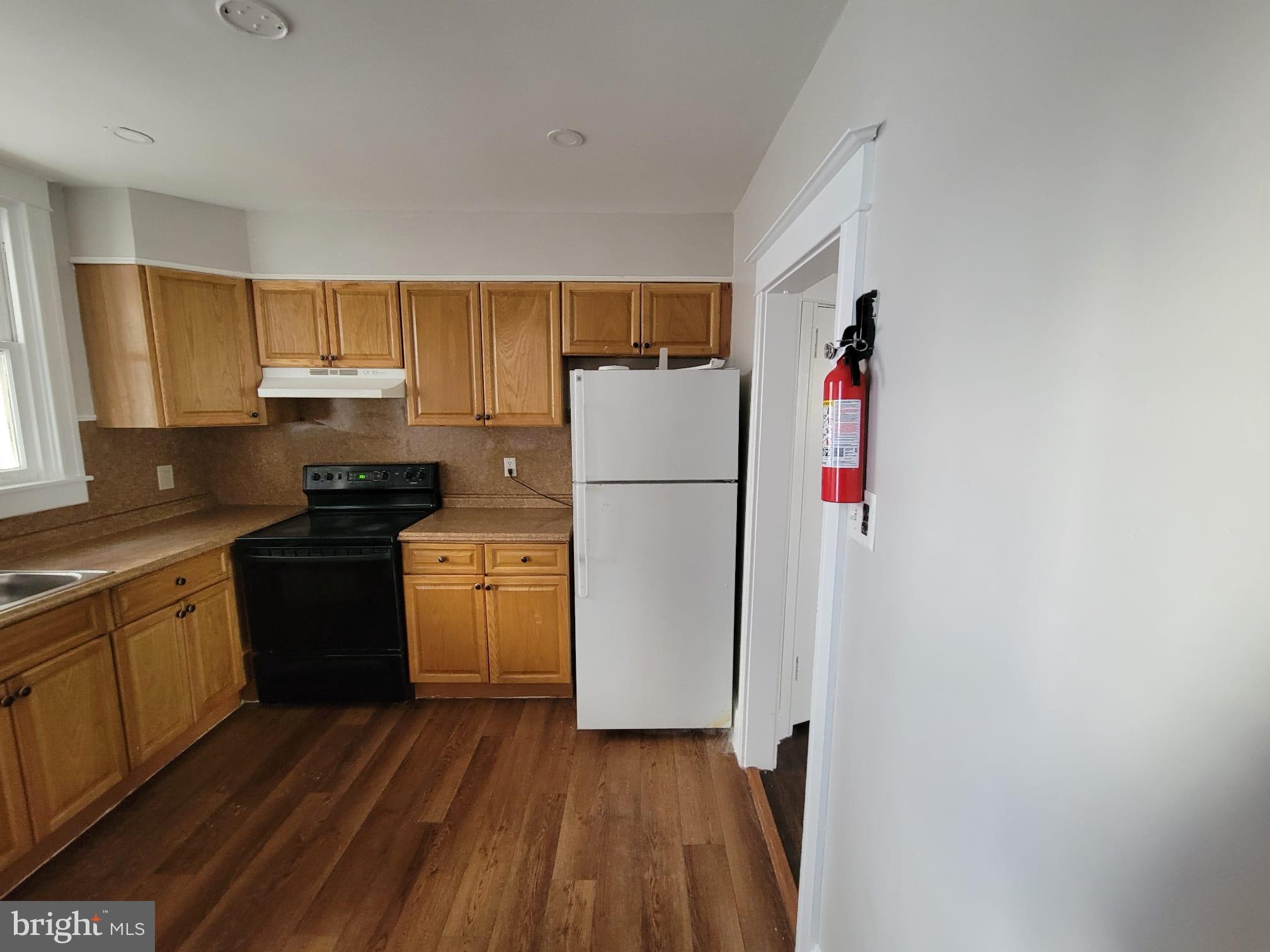 7243 Calvin Road Upper Darby, PA 19082 - Photo 8 of 29 a kitchen with a refrigerator and a stove top oven
