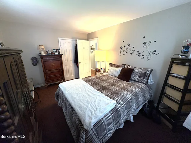 a bedroom with bed and wooden floor