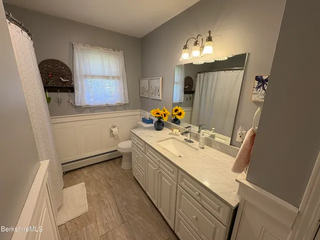 a bathroom with a toilet sink and mirror