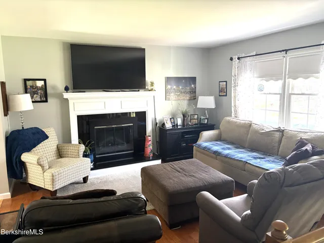 a living room with furniture a flat screen tv and a fireplace