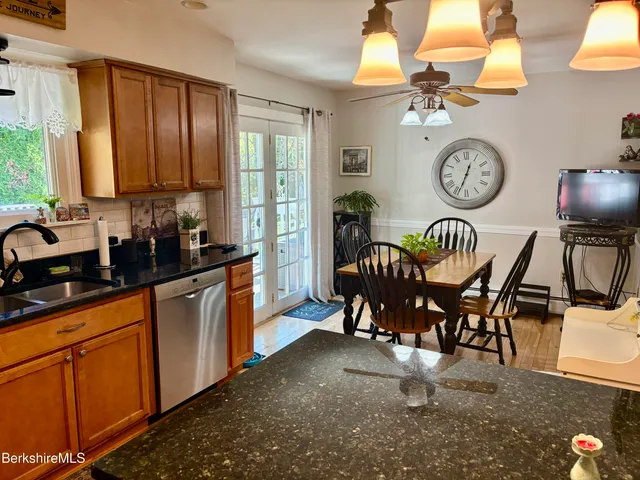 a view of a dining room and kitchen with furniture large window and chandelier