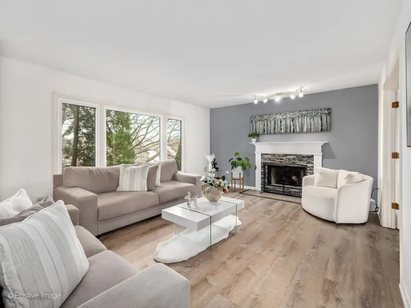 a living room with furniture a fireplace and a large window