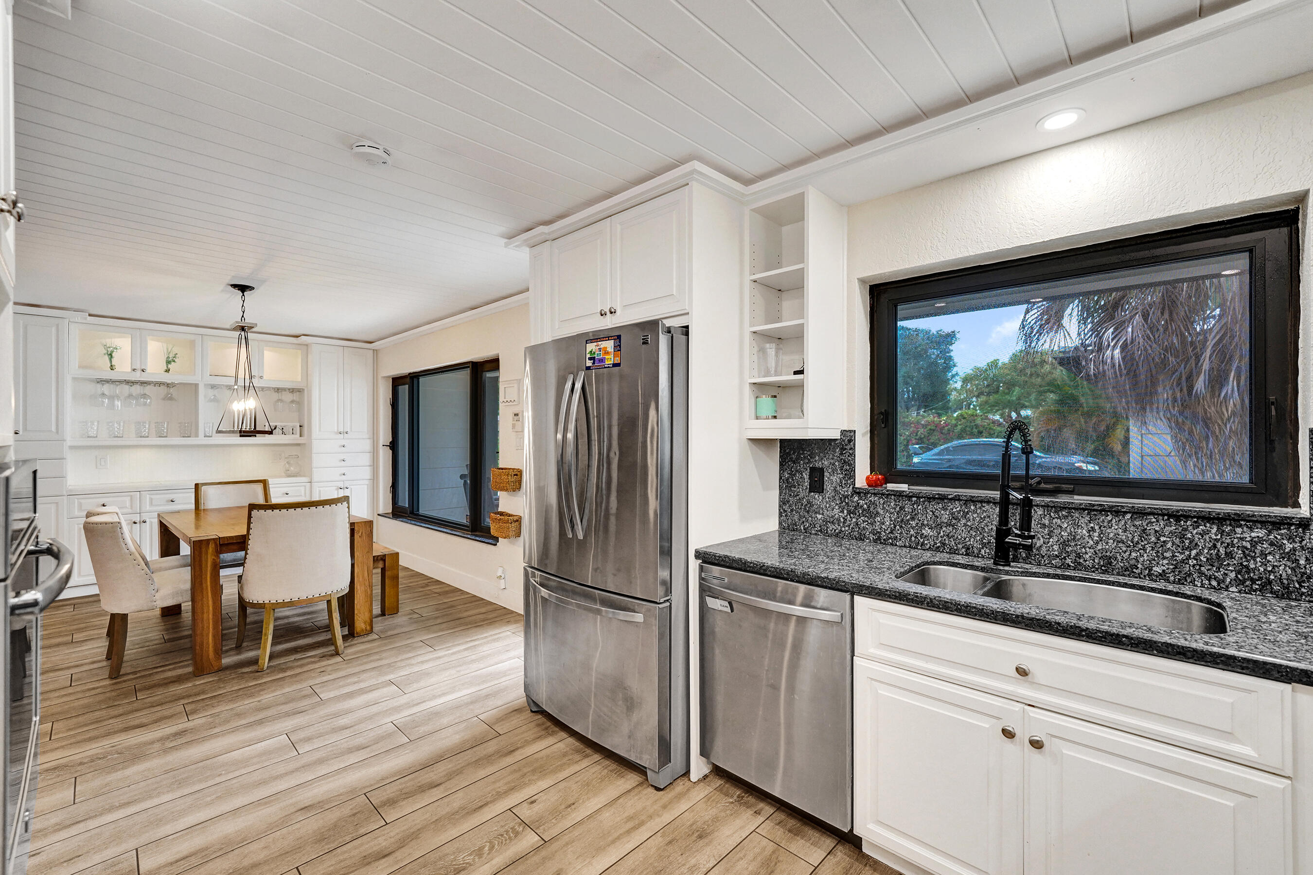 5612 Harding Street Hollywood, FL 33021 - Photo 5 of 52 a kitchen with stainless steel appliances granite countertop a refrigerator a sink and white cabinets with wooden floor