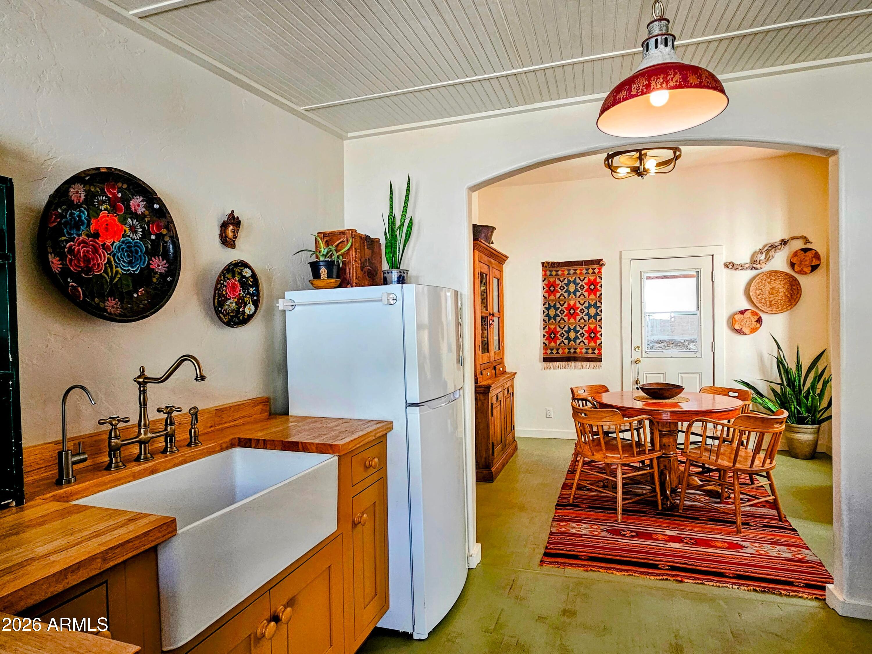 138 B Opera Drive Bisbee, AZ 85603 - Photo 14 of 34 a living room with a dining table and paintings on the wall