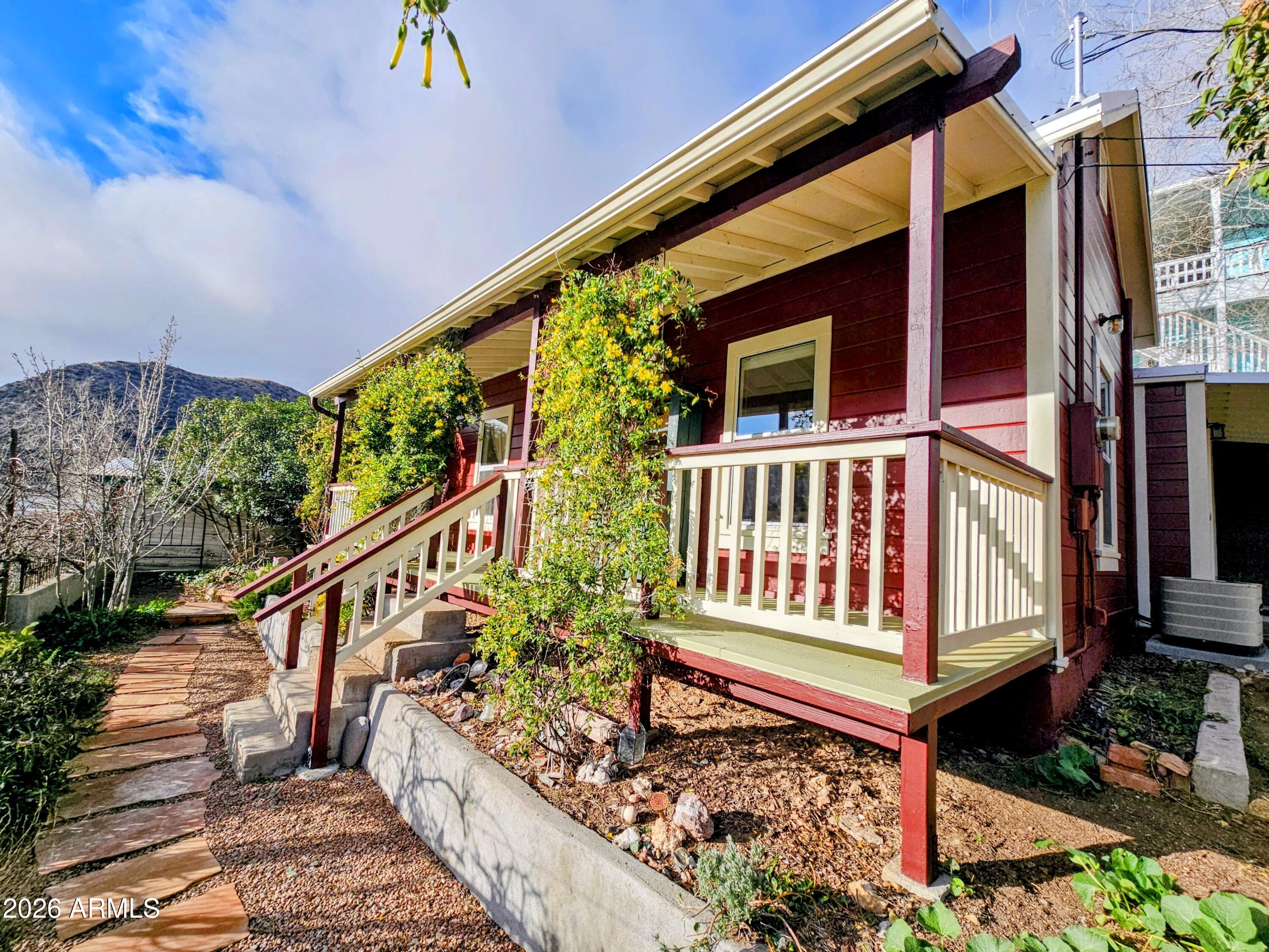 138 B Opera Drive Bisbee, AZ 85603 - Photo 4 of 34 a view of a house with wooden deck stairs and a potted plant