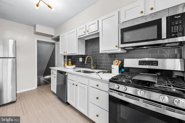 a kitchen with a sink a refrigerator and a stove