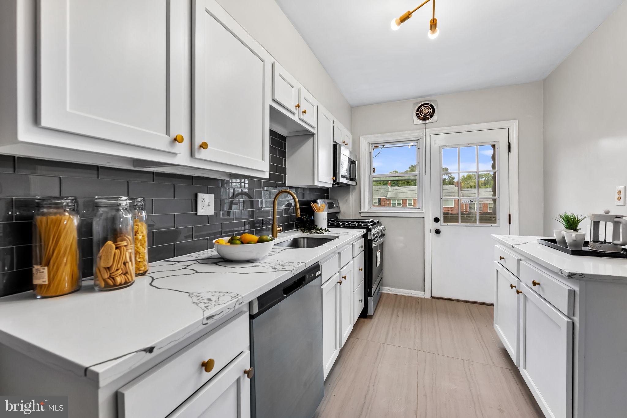 6216 Falkirk Road Baltimore, MD 21239 - Photo 13 of 27 a kitchen that has a lot of cabinets in it and wooden floors