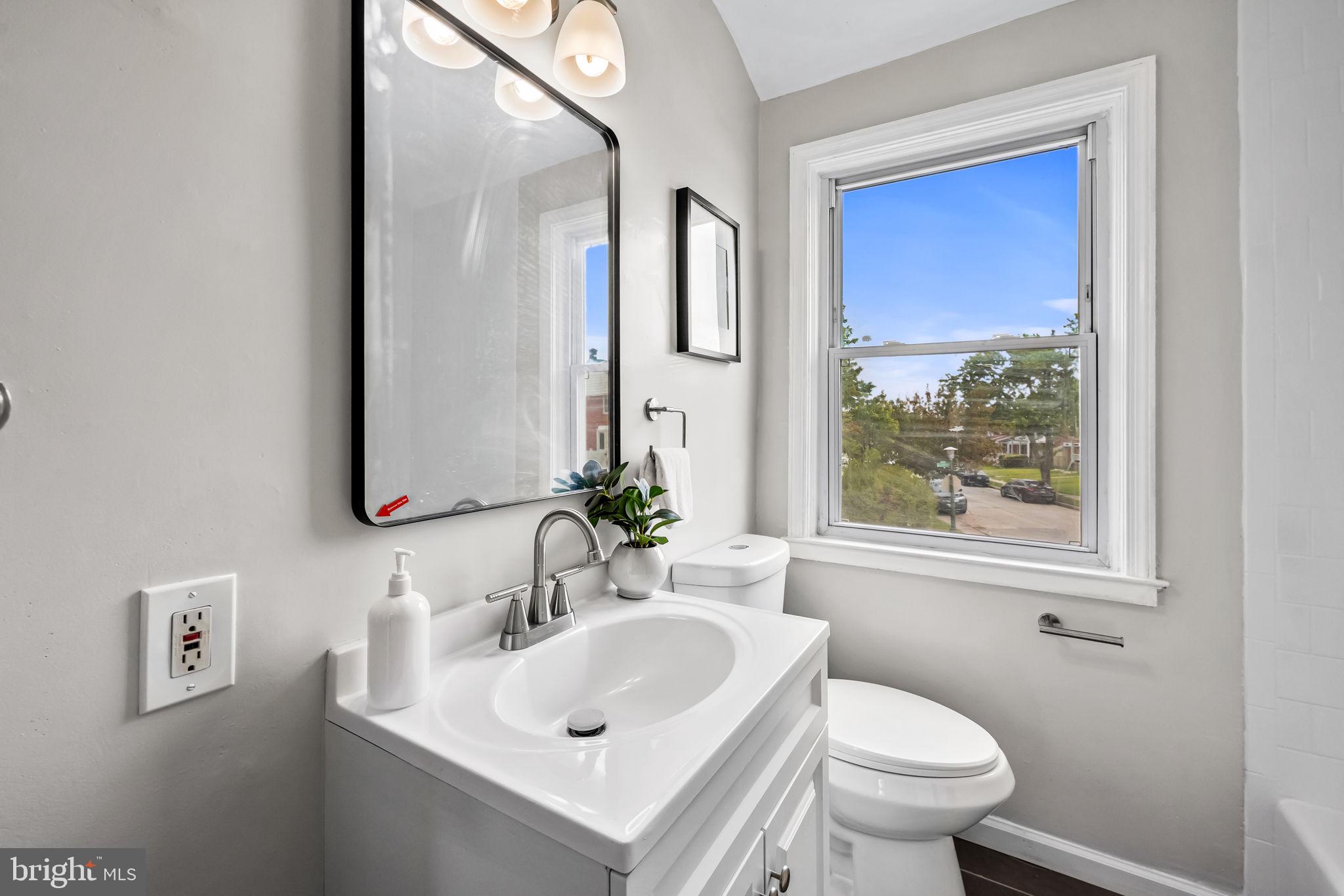 6216 Falkirk Road Baltimore, MD 21239 - Photo 17 of 27 a bathroom with a sink a toilet and a mirror