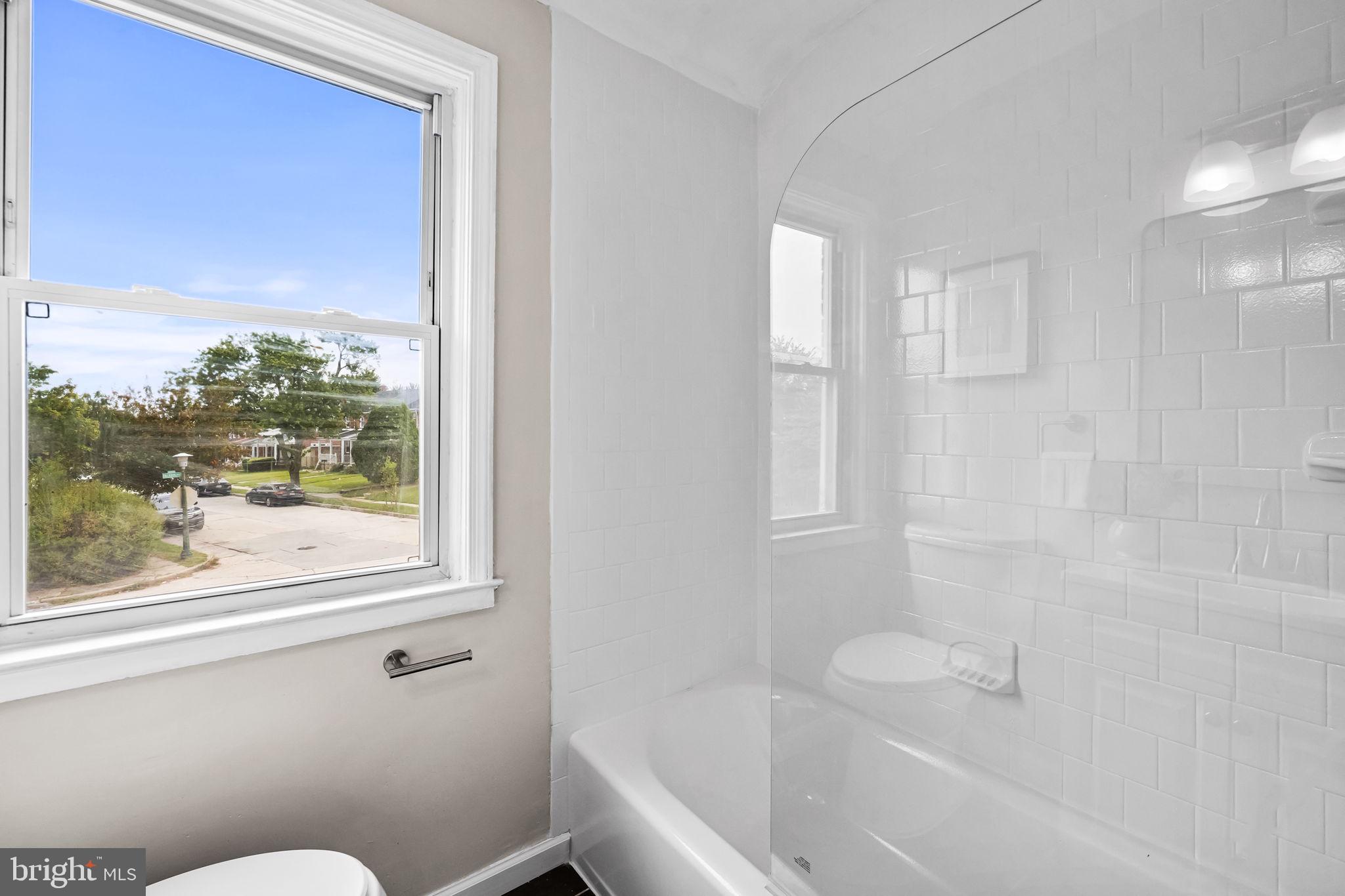 6216 Falkirk Road Baltimore, MD 21239 - Photo 18 of 27 a bathroom with a bathtub and window