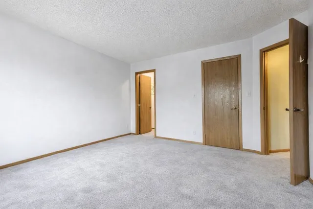 a view of an empty room with closet and a window