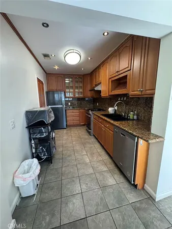 a kitchen with granite countertop a stove a sink dishwasher and a refrigerator