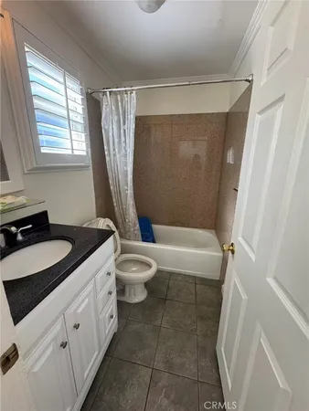 a bathroom with a sink a toilet a tub and shower